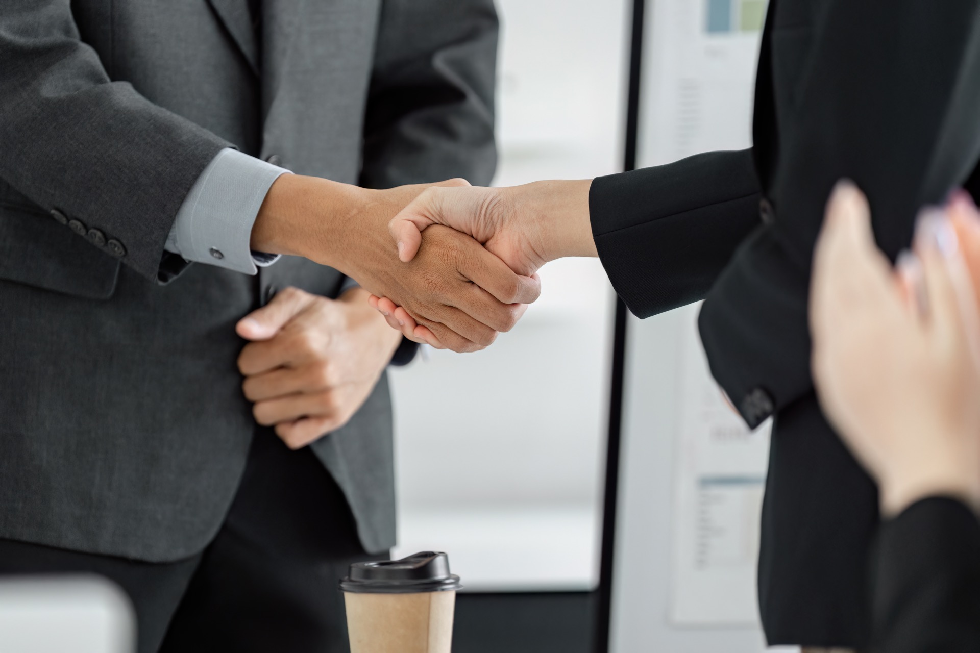 Business professionals shaking hands after a supplier review